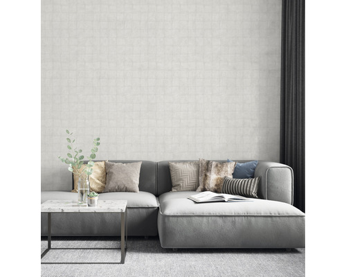 Vardagsrum med grå soffa, kuddar och mönstrad tapet för en ljus och modern atmosfär.