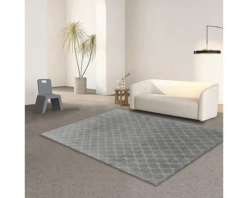 Vardagsrum med grå matta, soffa och stol.