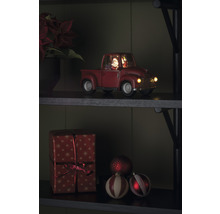 Dekorativ julbil med jultomte och present på en hylla