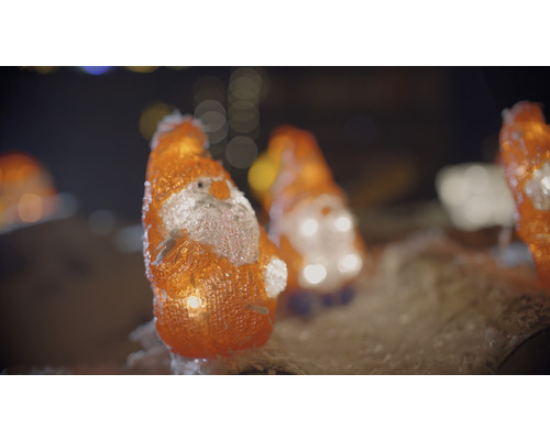 Flera upplysta jultomtefigurer som juldekoration
