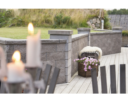 Trädgårdsmur av stenblock med dekoration på en träaltan