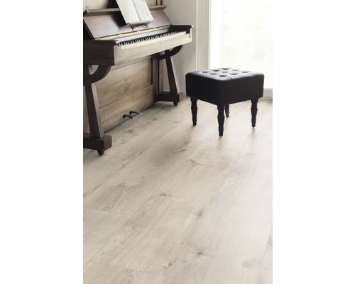 Ljust laminatgolv i ett rum med piano och pall