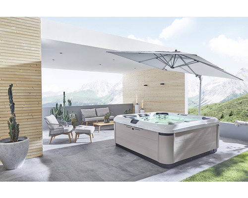 Bubbelpool på en terrass med trädgårdsmöbler och parasoll