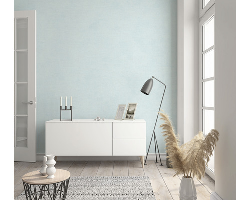 Ljust vardagsrum med byrå, golvlampa och dekoration