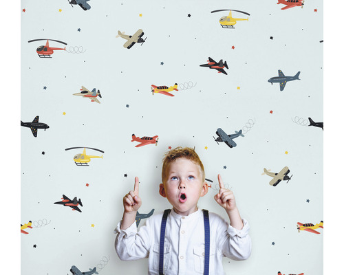 Barn framför en tapet med flygplansmönster