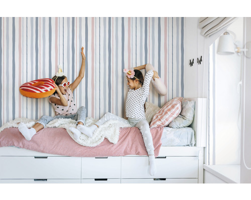 Flickrum med randig tapet, säng och lådor