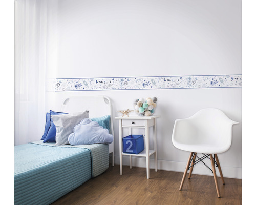 Barnrum med gräns med rymdmotiv, säng, nattduksbord och stol.