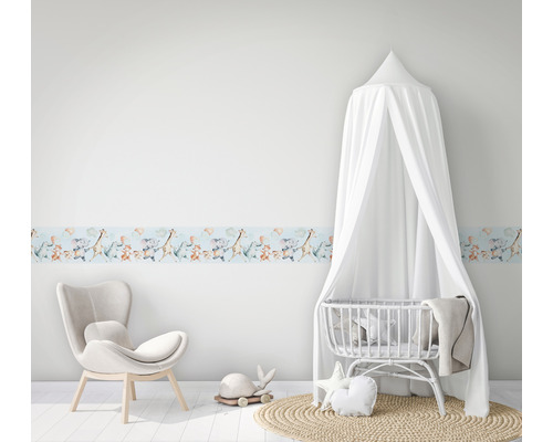 Barnrum med en bord med djurmotiv, en stol och en spjälsäng med sänghimmel.