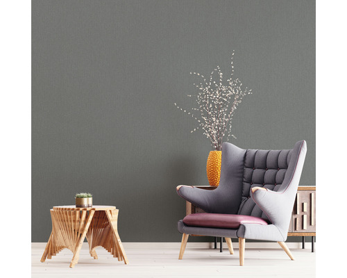 Vardagsrum med grå tapet, fåtölj och sidobord