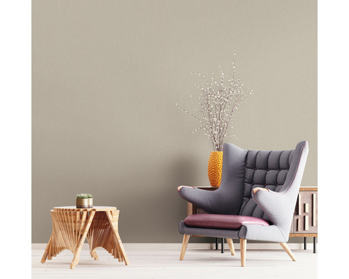 Vardagsrum med beige tapet, fåtölj och träbord