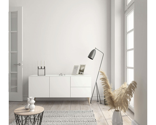 Ljust vardagsrum med skänk, golvlampa och dekoration