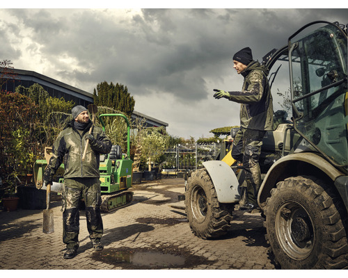 Två arbetare i arbetskläder, en arbetare håller en spade, en arbetare sitter i en traktor