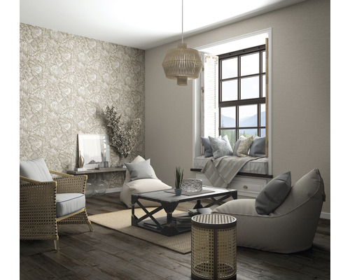 Vardagsrum med rottingmöbler, mönstrad tapet, fönsterplats och trägolv för en ljus och organiserad atmosfär.