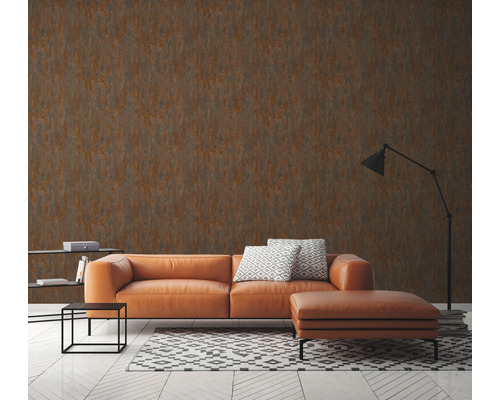 Vardagsrum med brun tapet i rostlook, soffa och golvlampa