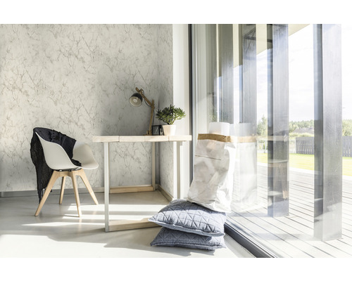 Ljust rum med marmortapet, skrivbord, stol och dagsljus.