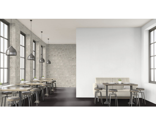 Restauranginteriör med bord, stolar och stenväggar