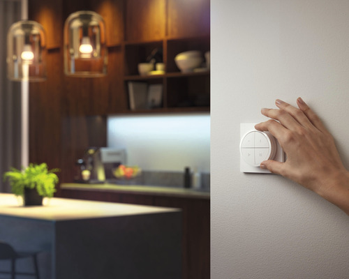 En hand manövrerar en ljusströmbrytare i ett modernt designat rum.