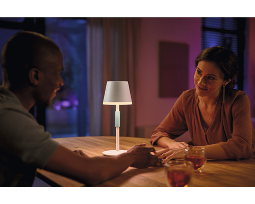 Par sitter vid bord med Hue bordslampa för stämningsbelysning