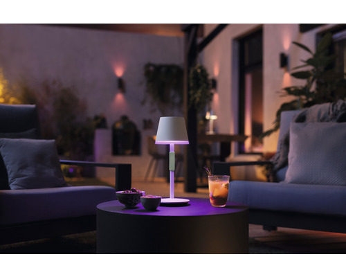 Belyst terrass med bordslampa, dryck och sittplatser