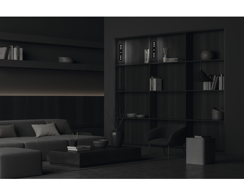 Vardagsrum med soffa, fåtölj, bokhylla och soffbord för en stilren inredning