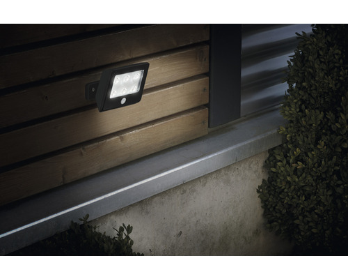 Utomhusvägglampa med rörelsedetektor på en trävägg