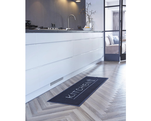 Köksscen med kökslöpare på parkettgolv framför köksdel