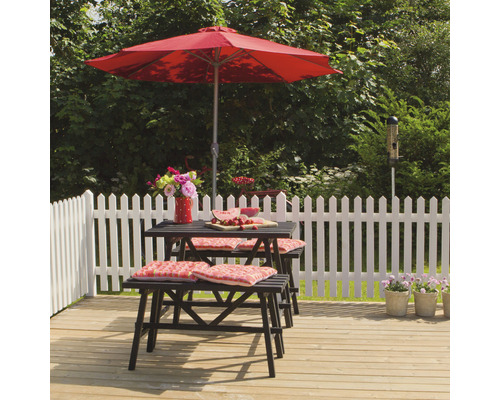 Trädgårdsscen med bord, bänkar, parasoll och dekoration på en träterrass framför ett trädgårdsstaket