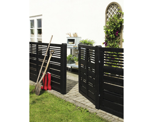 Trädgårdsscen med trästaket, spade och gummistövlar