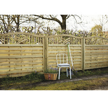 Trästaket med dekorativ finish, trädgårdsstol och växtkorg i trädgården