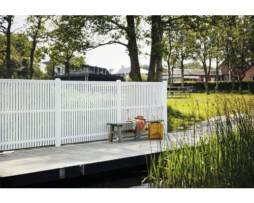 Vy med en vit staket vid en sjöstrand