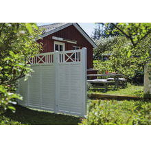 Trädgårdsscen med insynsskydd framför ett bostadshus