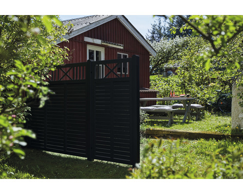 Trädgårdsscen med trästaket, bord och trädgårdshus