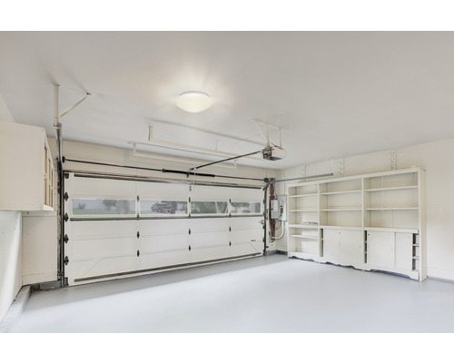 Garage med skåp, hyllor och garageport