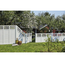Trästaket med trädgårdsport framför ett bostadshus