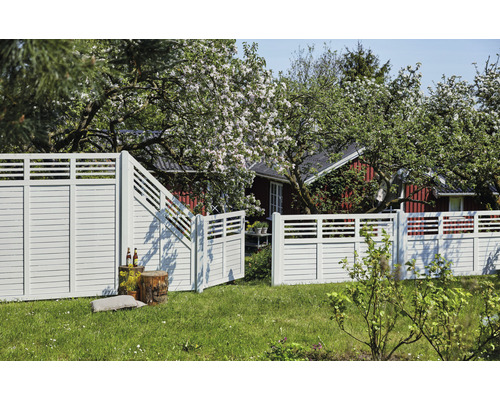 Trästaket med trädgårdsport framför ett bostadshus