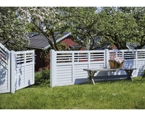 Trädgårdsscen med trästaket, trädgårdsport och trädgårdsbänk på en gräsmatta