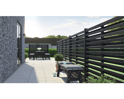 Terrass med trästaket, sittbänk och bordgrupp för utomhusbruk.