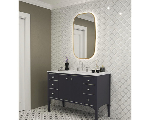 Badrum med tvättställ, spegel med belysning och mönstrade plattor på vägg och golv