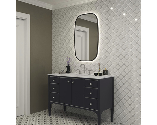 Badrum med tvättställ, spegel med belysning och mönstrade plattor