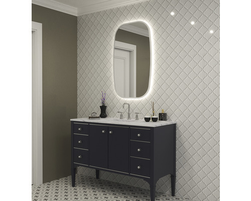 Modernt badrum med tvättställ, spegel med belysning och mönstrade kakelplattor