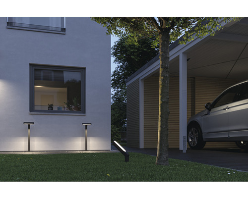 Scen med hus, carport och trädgårdsbelysning