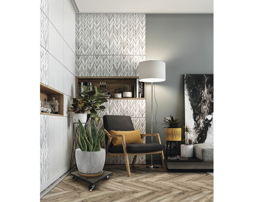 Vardagsrum med fåtölj, golvlampa, krukväxter och vägghyllor