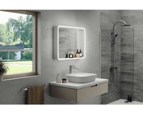 Modernt badrum med handfat, belyst spegel och dusch.