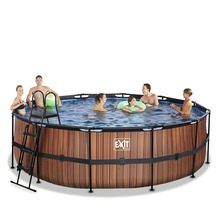 Rund pool med träpanel, stege och flera personer i vattnet.