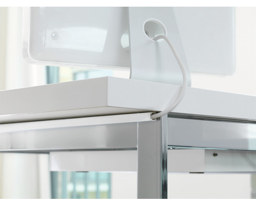 Detaljvy av ett skrivbord med kabelhantering och en ansluten monitor.