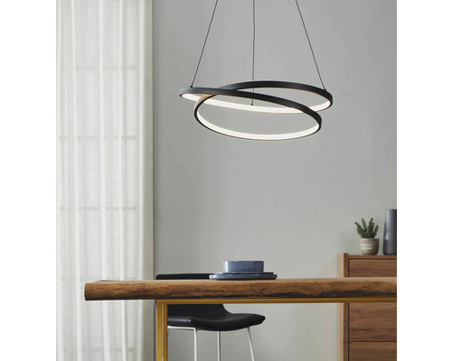 Modern pendellampa med tre sammanflätade ringar av metall och integrerad LED-belysning ovanför ett matbord