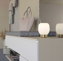 Dekorativ inredning med handväska och bordslampor på ett skåp