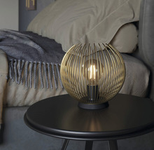 Dekorativ bordslampa med sfärisk lampskärm på ett sängbord