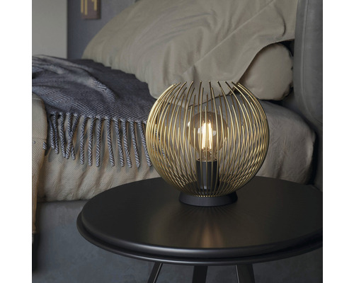 Dekorativ bordslampa med sfärisk lampskärm på ett sängbord