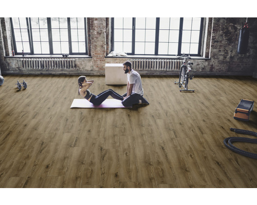 Ljust gym med trägolv, idrottare och träningsutrustning